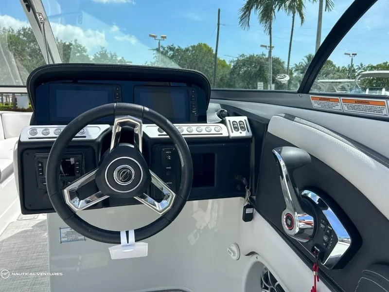 Slide: The Image of 2024 Crownline E290 XS boat helm with steering wheel and control panel. - 4