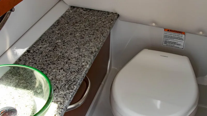 Slide: The Image of 2023 Crownline 290 XSS boat interior with granite countertop and modern toilet. - 15