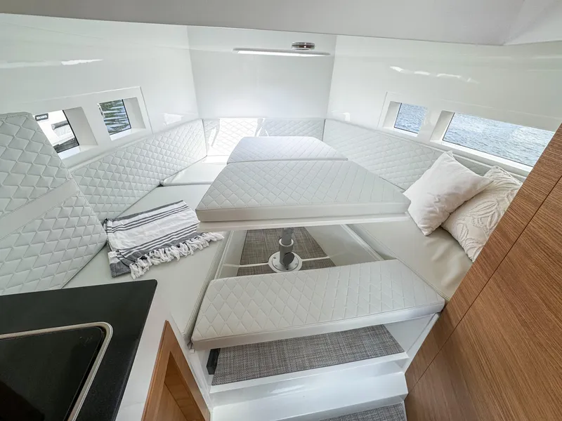 Slide: The Image of 2024 De Antonio Yachts D28 Cruiser interior with white quilted seating and modern design. - 12