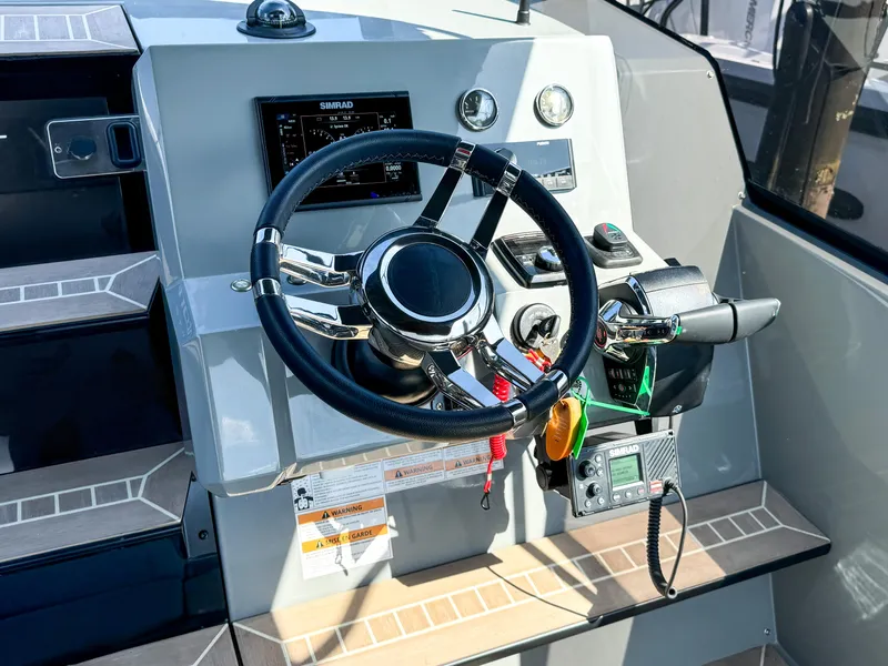 Slide: The Image of 2024 De Antonio Yachts D28 Cruiser helm with steering wheel and control panel. - 7