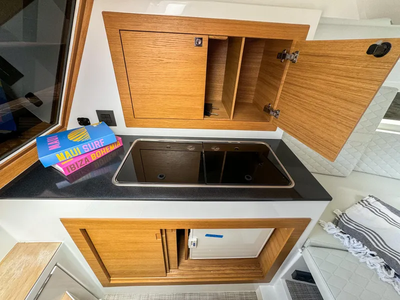 Slide: The Image of Compact kitchen area in 2024 De Antonio Yachts D28 Cruiser with wooden cabinets and a sleek countertop. - 9