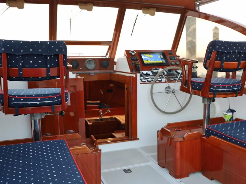 Slide: The Image of Interior of a 1995 Able 44 boat with wooden helm and blue cushioned seats. - 10