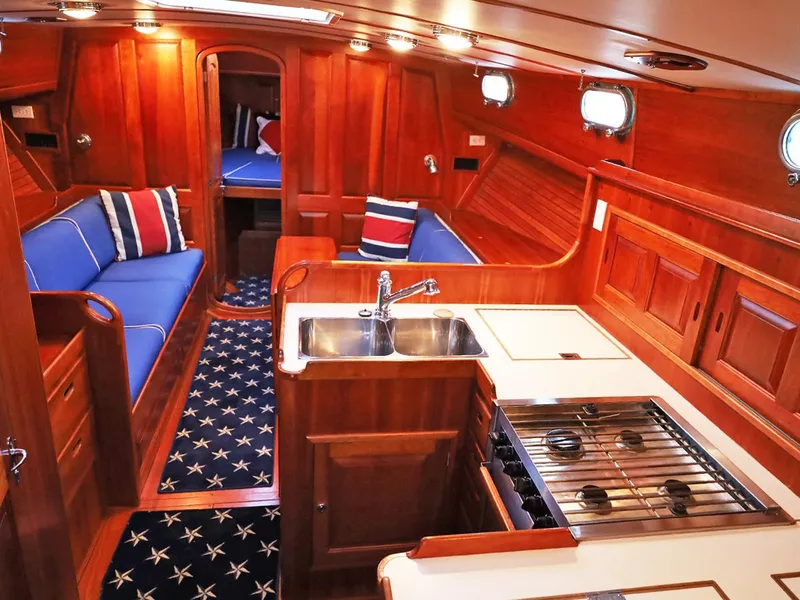 Slide: The Image of Luxurious 1995 Able 44 yacht interior with wood finish, blue seating, and nautical decor. - 11