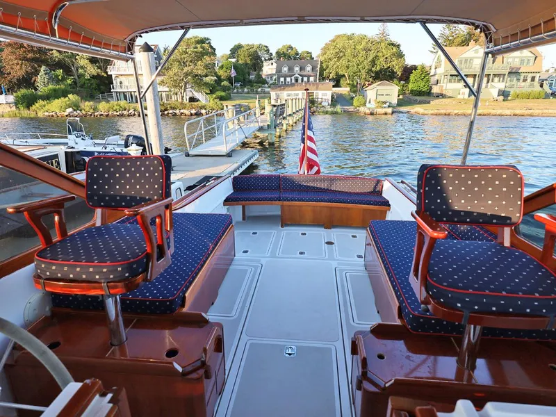 Slide: The Image of Interior of 1995 Able 44 boat with blue cushioned seating and American flag. - 8