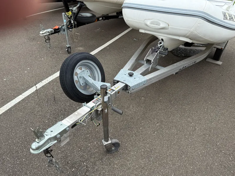 Slide: The Image of Trailer for 2011 Walker Bay Console Genesis 310FTD boat in parking lot. - 2