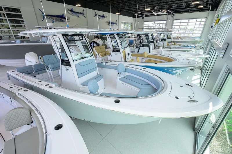 Slide: The Image of 2026 Sportsman Heritage 231 Center Console boats displayed in a showroom. - 1
