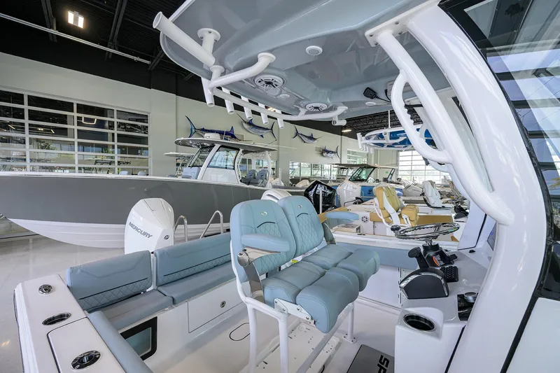 Slide: The Image of 2026 Sportsman Heritage 231 Center Console boat interior in showroom, featuring modern seating and controls. - 10