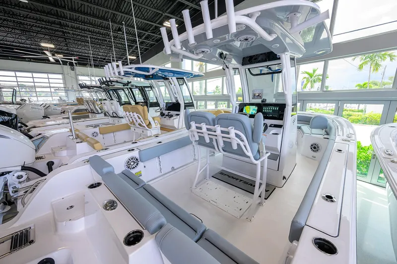 Slide: The Image of 2026 Sportsman Heritage 231 Center Console boat interior in showroom, featuring modern seating and controls. - 17