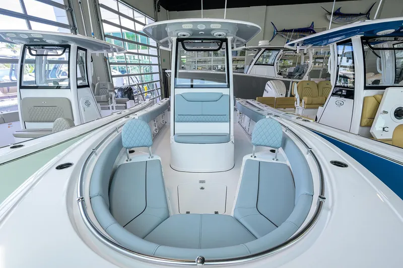 Slide: The Image of 2026 Sportsman Heritage 231 Center Console boat interior with blue seating in showroom. - 2