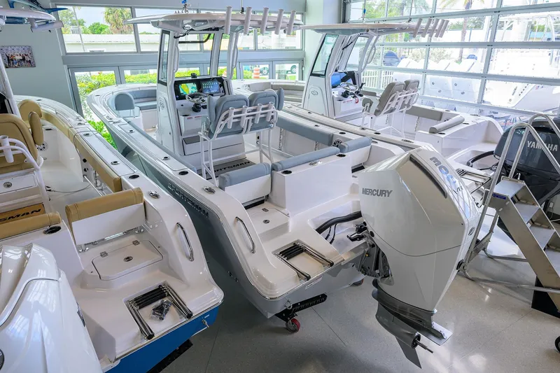 Slide: The Image of 2026 Sportsman Heritage 231 Center Console boat in showroom with Mercury engine. - 28