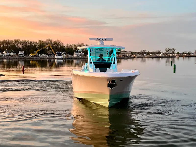 Slide: The Image of 2026 Wellcraft 352 Fisherman boat cruising on calm water at sunset. - 11