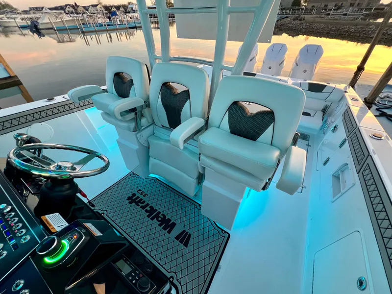 Slide: The Image of 2026 Wellcraft 352 Fisherman boat interior with illuminated seating and control panel at sunset. - 19