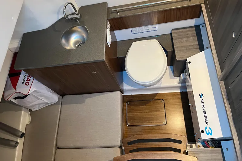 Slide: The Image of 2026 Wellcraft 352 Fisherman interior with sink, toilet, and Seakeeper stabilizer. - 27