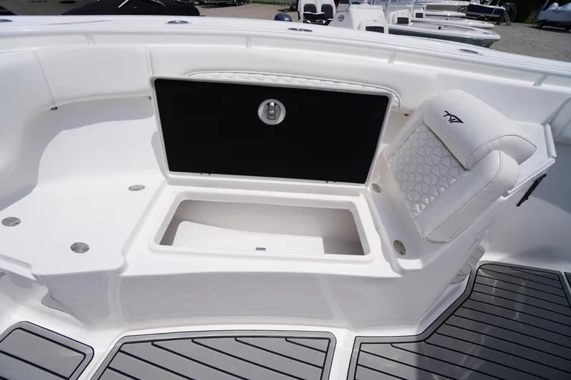 Slide: The Image of 2026 Tidewater 282 CC Adventure boat interior with storage compartment and cushioned seating. - 17
