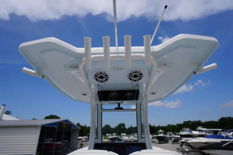 Slide: The Image of 2026 Tidewater 282 CC Adventure boat with T-top and rod holders under a clear blue sky. - 37
