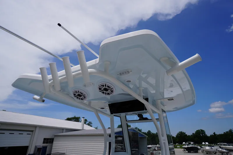 Slide: The Image of 2026 Tidewater 282 CC Adventure boat with rod holders and speakers under a clear blue sky. - 38