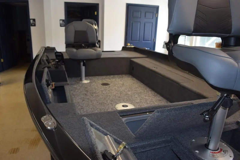 Slide: The Image of Interior of 2025 Tracker Super Guide V16 T boat with seating and carpeted deck. - 15