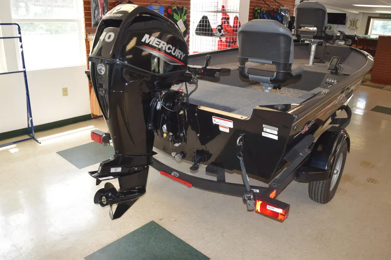 Slide: The Image of 2025 Tracker Super Guide V16 T boat with Mercury 40 engine, displayed indoors. - 4