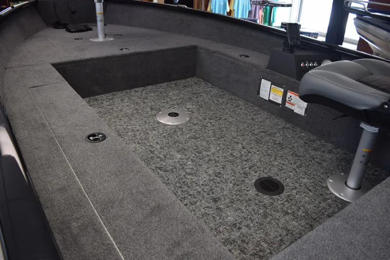 Slide: The Image of 2025 Tracker Super Guide V16 T boat interior with gray carpet and seating. - 6