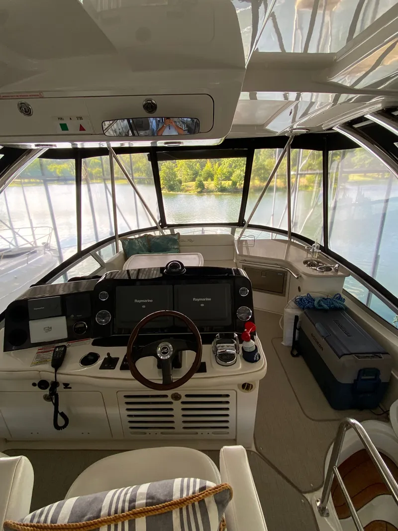 Slide: The Image of 2008 Sea Ray 47DB yacht cockpit with steering wheel, navigation screens, and lake view. - 26