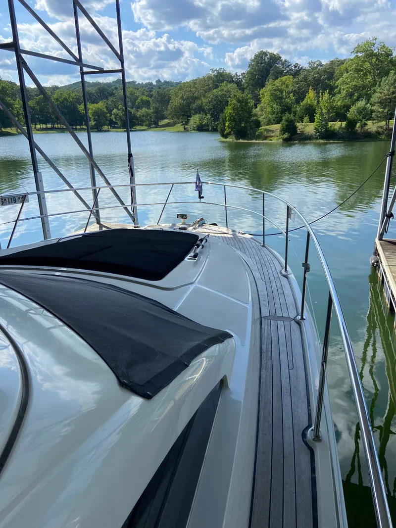 Slide: The Image of 2008 Sea Ray 47DB yacht docked on a serene lake with lush greenery. - 32