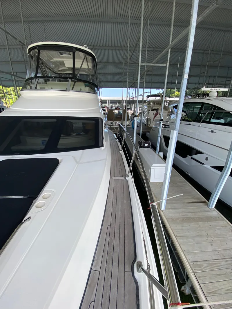 Slide: The Image of 2008 Sea Ray 47DB yacht docked in a marina, showcasing sleek design and spacious deck. - 35