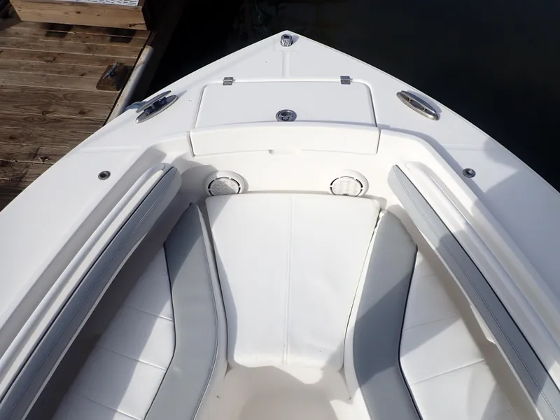 Slide: The Image of 2020 Regulator 23 Center Console boat bow with cushioned seating and storage compartments. - 18