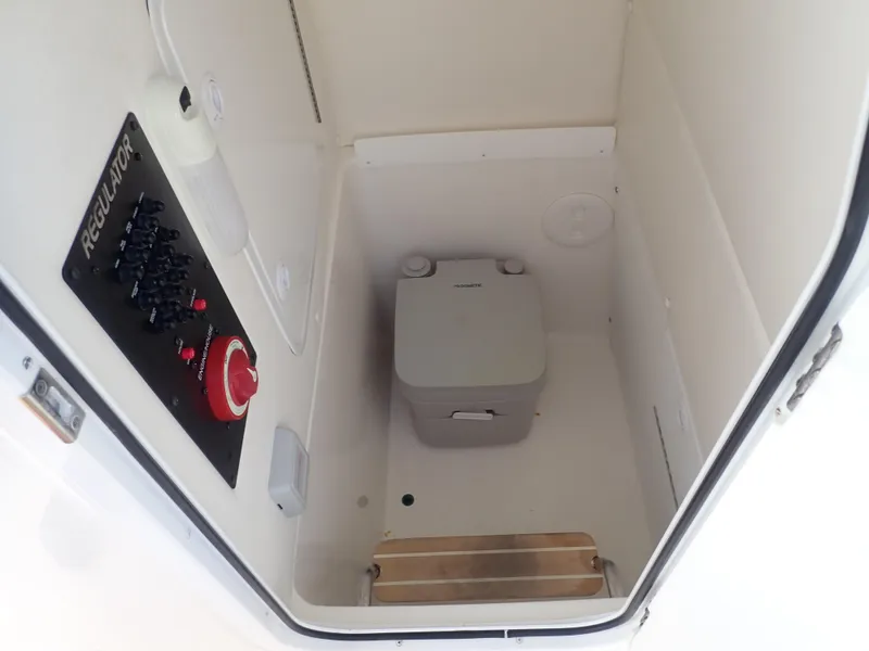Slide: The Image of Interior of 2020 Regulator 23 Center Console boat with portable toilet and control panel. - 24