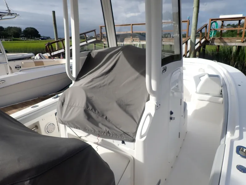 Slide: The Image of 2020 Regulator 23 Center Console boat with covered seating, docked near wooden pier. - 7