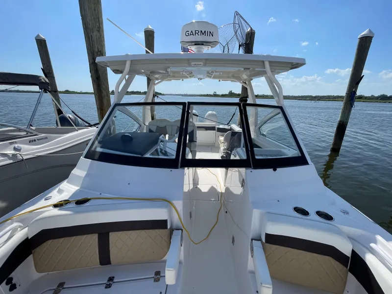 Slide: The Image of 2021 Edgewater 262 CX boat docked, featuring Garmin equipment and spacious seating. - 11