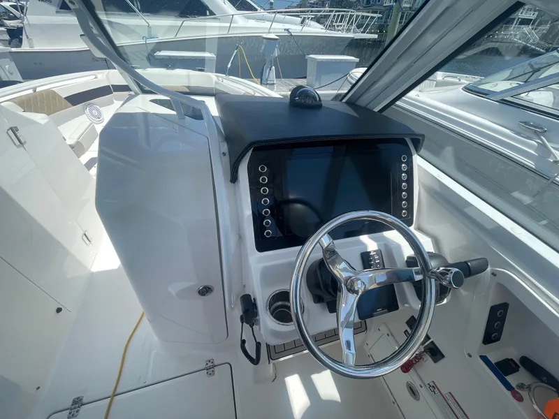 Slide: The Image of 2021 Edgewater 262 CX boat cockpit with steering wheel and control panel. - 14