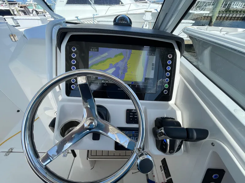 Slide: The Image of Edgewater 262 CX 2021 boat helm with navigation display and steering wheel. - 15