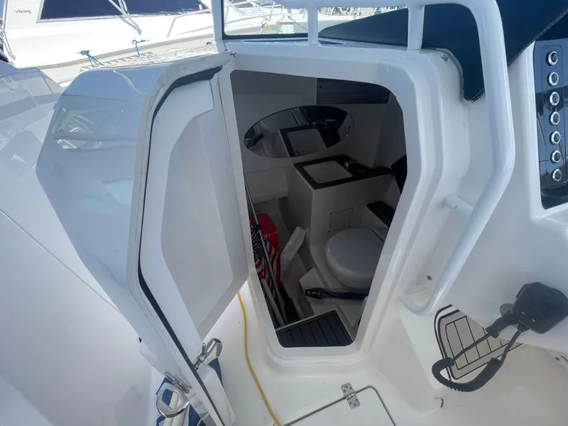Slide: The Image of 2021 Edgewater 262 CX boat interior with open door, showing compact cabin space. - 26