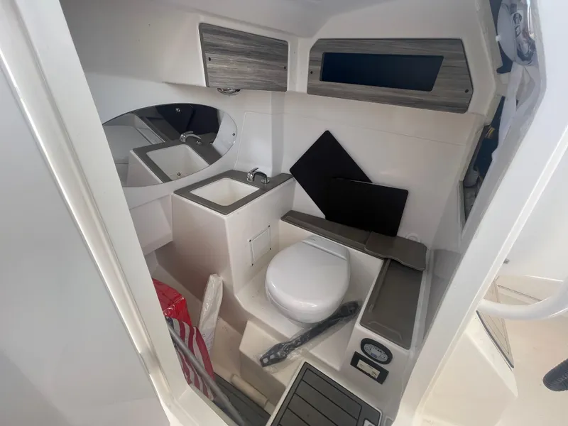 Slide: The Image of 2021 Edgewater 262 CX boat interior with compact bathroom and sink. - 27