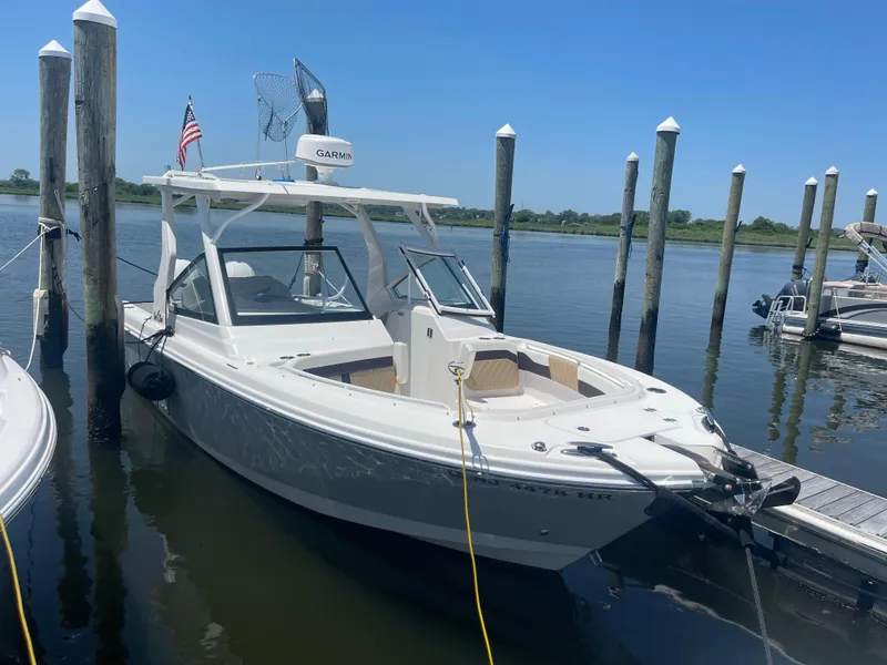 Slide: The Image of 2021 Edgewater 262 CX boat docked at marina with clear blue sky. - 3