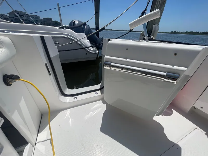 Slide: The Image of 2021 Edgewater 262 CX boat interior with open door, docked by the water. - 33
