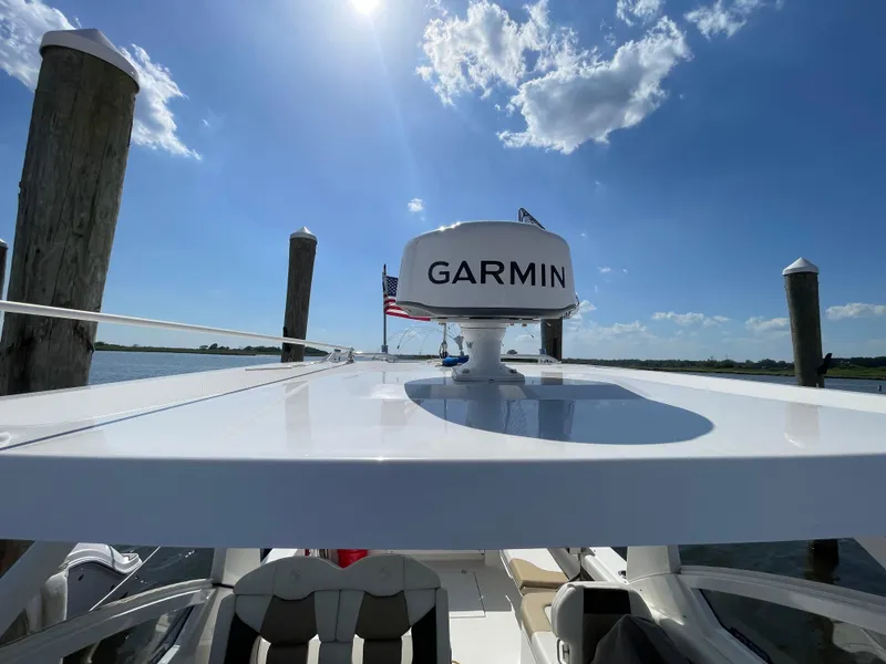 Slide: The Image of 2021 Edgewater 262 CX boat with Garmin radar, docked under a sunny sky. - 36