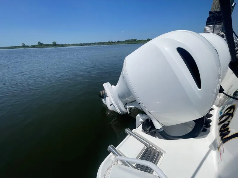Slide: The Image of 2021 Edgewater 262 CX boat engine on calm water under clear blue sky. - 38