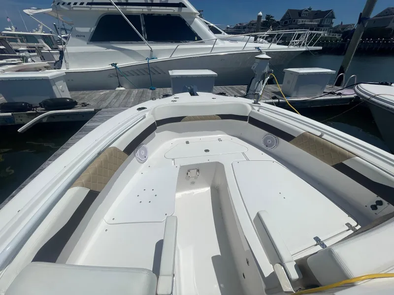 Slide: The Image of 2021 Edgewater 262 CX boat interior at marina, featuring spacious seating and modern design. - 5