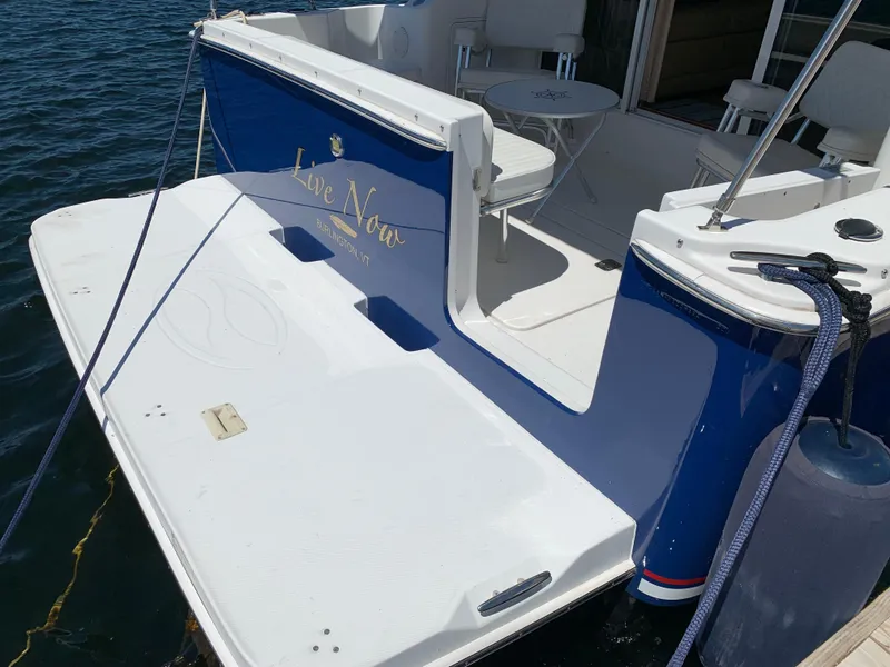 Slide: The Image of 2012 Silverton 33 Sport Coupe boat docked, featuring a spacious deck and seating area. - 10