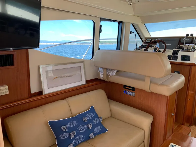Slide: The Image of Interior of 2012 Silverton 33 Sport Coupe with beige seating and nautical decor. - 13