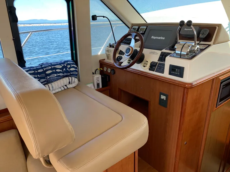 Slide: The Image of Interior helm of 2012 Silverton 33 Sport Coupe with navigation equipment and leather seating. - 16