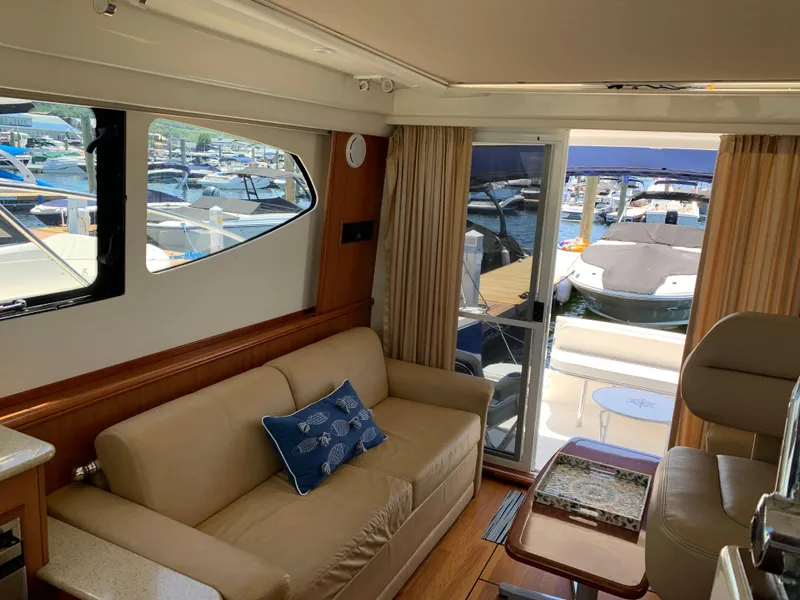 Slide: The Image of Interior of 2012 Silverton 33 Sport Coupe yacht with sofa and marina view. - 18