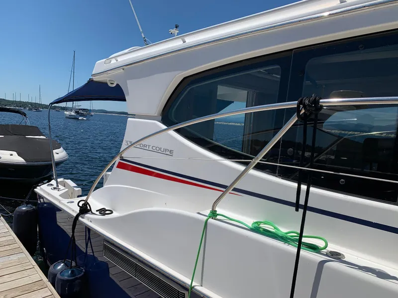 Slide: The Image of 2012 Silverton 33 Sport Coupe docked by the water on a sunny day. - 2