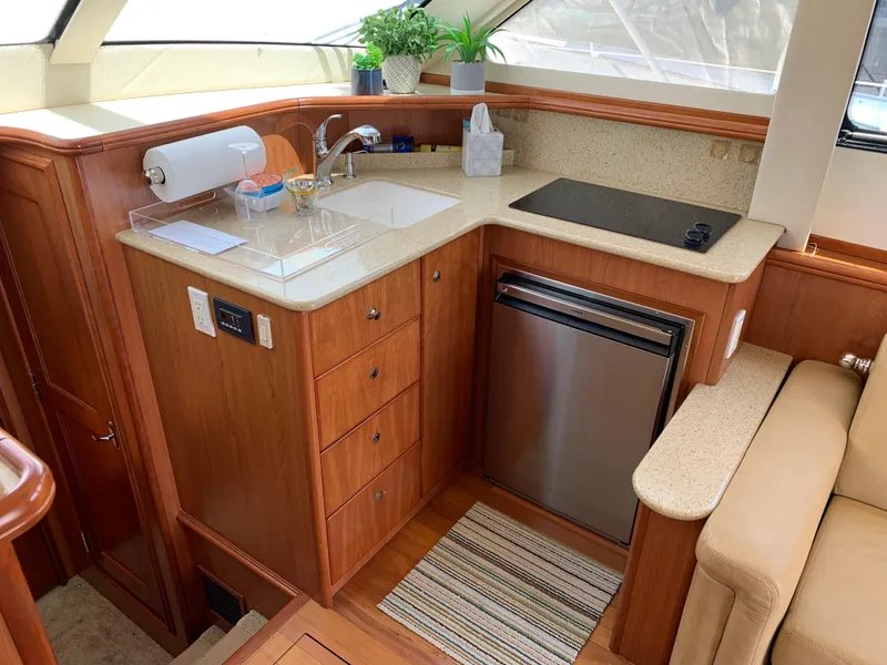 Slide: The Image of 2012 Silverton 33 Sport Coupe yacht kitchen with wood cabinetry and modern appliances. - 21