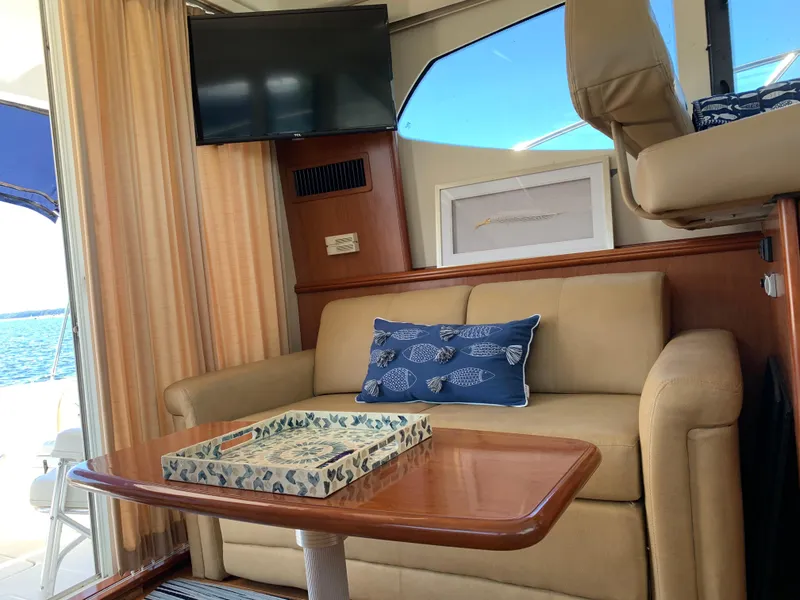 Slide: The Image of Interior of 2012 Silverton 33 Sport Coupe with beige sofa, TV, and nautical decor. - 23