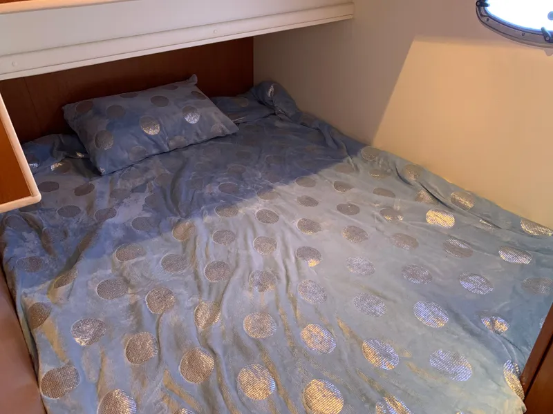 Slide: The Image of Cozy bed with blue polka dot bedding in 2012 Silverton 33 Sport Coupe cabin. - 34