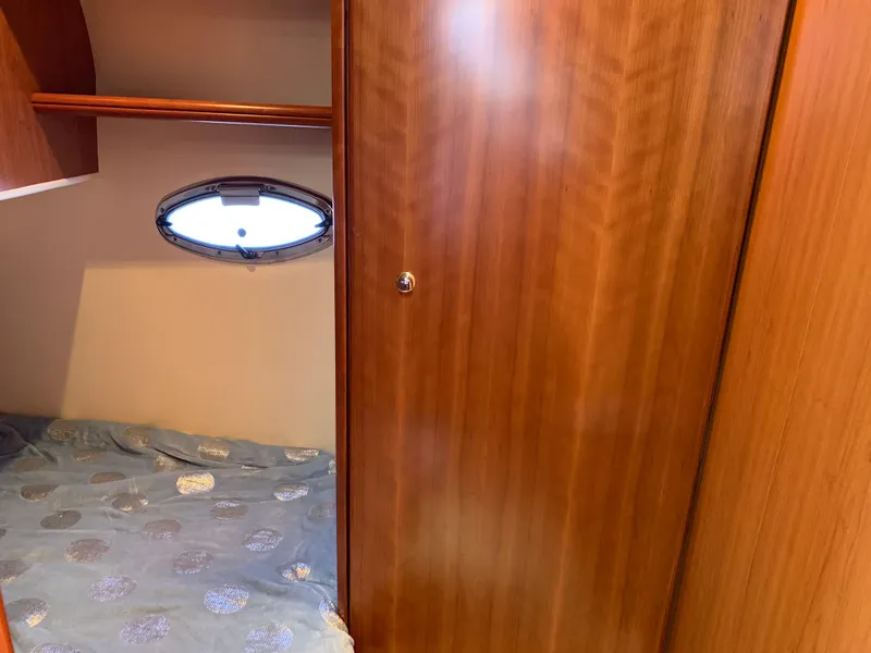 Slide: The Image of 2012 Silverton 33 Sport Coupe cabin interior with wooden paneling and porthole window. - 35