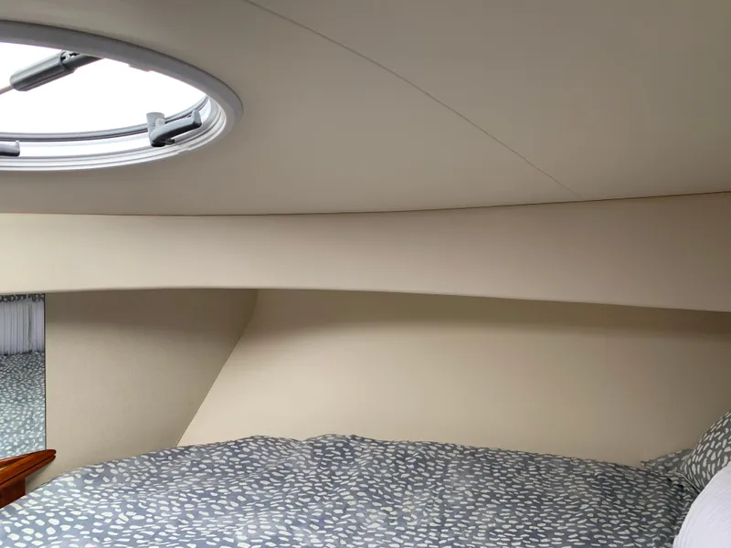 Slide: The Image of Interior cabin of 2012 Silverton 33 Sport Coupe with circular window and patterned bedding. - 39