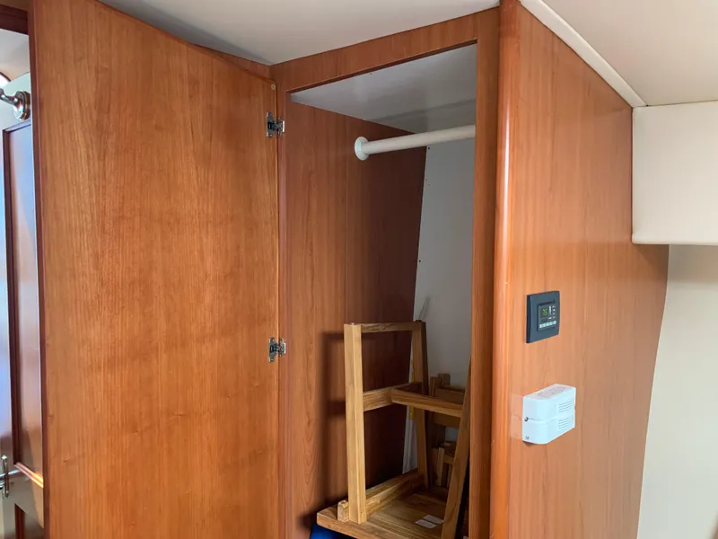 Slide: The Image of Interior wooden closet in 2012 Silverton 33 Sport Coupe yacht, featuring open door and shelving. - 42